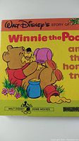 Front of the home movie box featuring the title and artwork of Winnie the Pooh with honey pots.
