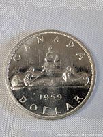 Obverse side of 1959 Canadian silver dollar coin showing voyageur canoe design with inscription 'CANADA DOLLAR 1959'.