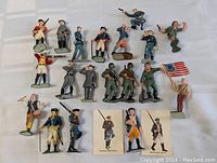 Full view of 21 vintage 1960s Marx Famous Military Figures in various poses and uniforms including American Revolutionary War and Civil War style soldiers. Includes figures holding rifles, pistols, flags, and a drummer.