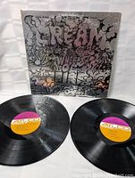 Two black vinyl records with Atco labels lying next to the album cover on a white background. Records appear clean and shiny with minor surface marks.