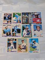 12 vintage Montreal Expos baseball cards neatly arranged on a white surface, featuring players Gary Carter, Andre Dawson, Steve Rogers, Warren Cromartie, Bill Gullickson, Jeff Reardon, Delino DeShields, and others.