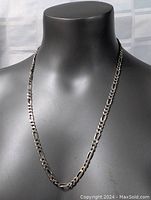 Necklace displayed on a black mannequin bust to show length and style.