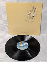 Vinyl record with original label showing a rainbow design and blue sky background.