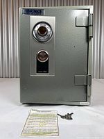 Full front view of safe on tabletop with keys and instruction sheet laid out