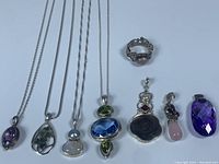 Overview of eight pieces including seven pendants and one ring laid out