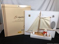 Full view of the boxed Steiff Le régatier sailboat with bear figurine resting in foam insert.
