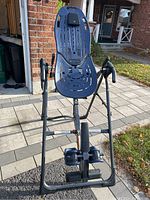 Full front view of Teeter FitSpine Inversion Table showing back support, frame, and ankle locks.