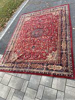 Full view of rug laid on driveway and pavement showing central medallion and border pattern
