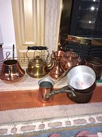 Group shot of all items including decorative pots, kettle, saucepans, coffee pot and music-themed wall decor