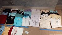 Full view of golf shirts arranged on carpet floor in different colors and styles including polo collars and mock neck shirts.