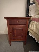 Front view of one nightstand showing drawer above cabinet door