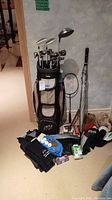 Overview of golf bag with clubs, racket, umbrella and headcovers