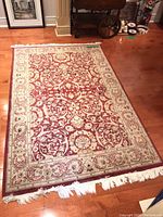 Full view of the area rug laid on hardwood floor showing its size and intricate design.