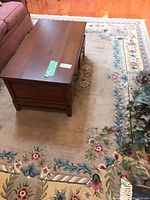 Wool area rug under a coffee table, showing overall condition and placement in room.