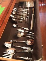 Overall view of flatware set in drawer showing forks, spoons and knives