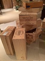 Eight wooden wine and champagne crates stacked and arranged inside an indoor space showing various branding.