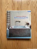 Front cover of the book 'Bathrooms: Just Add Water' by Terence Conran, showing a large stone bathtub and minimalist decor.
