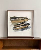 Front view of the framed modern abstract artwork 'Cadence II' by CEL-elements Studio on a wooden surface.