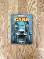 Front cover of 'The Pictorial History of Cars' book showing a vintage car and text with author and introduction.