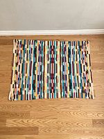 Top-down photo of rectangular vintage blanket laid flat showing full pattern and colors.