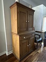Full view of closed pine cupboard showing overall appearance and panel doors.
