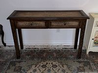 Front view showing two drawers with floral painted decoration and dark wood stain finish. Shows scratches on surface.