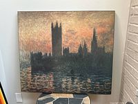 Full view of the large framed print showing dark silhouette of London House of Parliament against a colorful sunset sky reflecting on water.