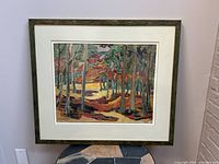 Full view of framed art print showing autumn forest scene and frame condition