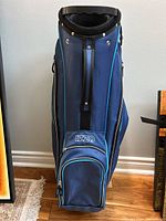 Front view showing navy blue Izzo golf bag with single carry strap and Izzo logo on front pocket