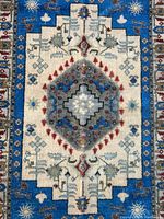 Close-up photo of the Persian style rug mat showing the central medallion, intricate printed design with blues, creams, reds, and greens, and textured surface.