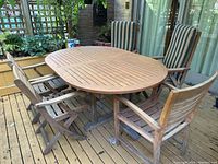 Five teak chairs arranged around a table (table not included)