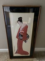 Photo showing full view of framed art print of Japanese Geisha woman in red kimono.