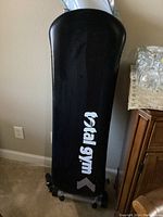 Total Gym APEX G1 fitness machine fully assembled and shown from above with black glide board and white logo on padded surface.