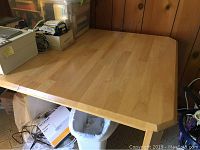 Clear view of the wooden table surface showing light wood finish and slight rounding on corners.