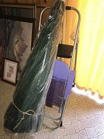 Photo showing the green outdoor folding chair wrapped in plastic along with purple folding chair and silver folding ladder