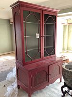 Full front view of red wooden display hutch showing upper and lower cabinets