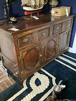 Front view of the wood sideboard cabinet showing three top drawers and three lower doors