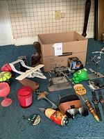 Wide view of lot showing model airplane, sculptures, beer tap handle, frog sharpener, glassware and cardboard box