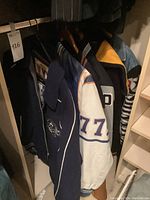 Multiple varsity jackets hanging in closet