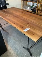 Side view showing wooden planks and wrought iron trestle leg.