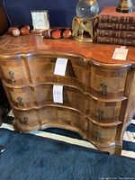 Front view showing serpentine curved front and three drawers