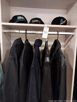 Five jackets hanging on shelf rack