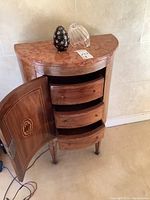 Front left view with cabinet door open showing three curved interior drawers and marble top