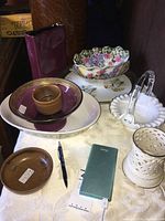 Lot arranged on a table with a mix of ceramic platters, bowls, and a vase including Lenox items with floral and grapevine patterns.