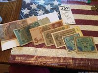 Seven German paper banknotes arranged on a surface showing various denominations including 20 Mark, 5 Mark, and 1 Mark notes.