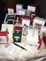 Photo showing the full assortment of Hallmark Keepsake boxed ornaments arranged on a cloth. Variety of different characters and commemorative styles visible.