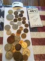 Top view of 30 Mexican coins in various sizes, metals and conditions, arranged on a white paper with a small white folded label marked 'MEX' and a handwritten note indicating 'Mexico Coins'.
