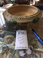 Close-up perspective of the Roseville console bowl on glass with pen for scale.