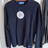 Black crewneck sweater by Jack & Jones labeled A, showing front, hanging on hanger.