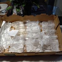 Box containing 11 Longchamp crystal water glasses, individually cushioned with tissue paper.
